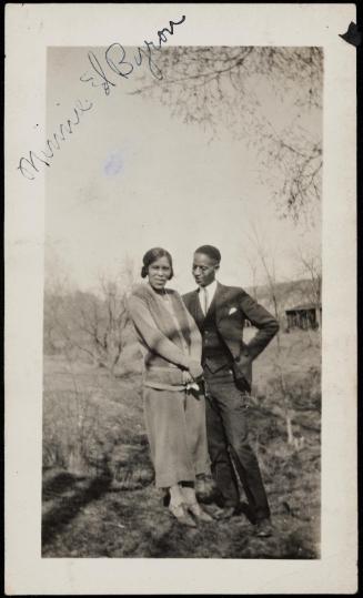 Portrait of a man and woman standing outdoors under tree limbs