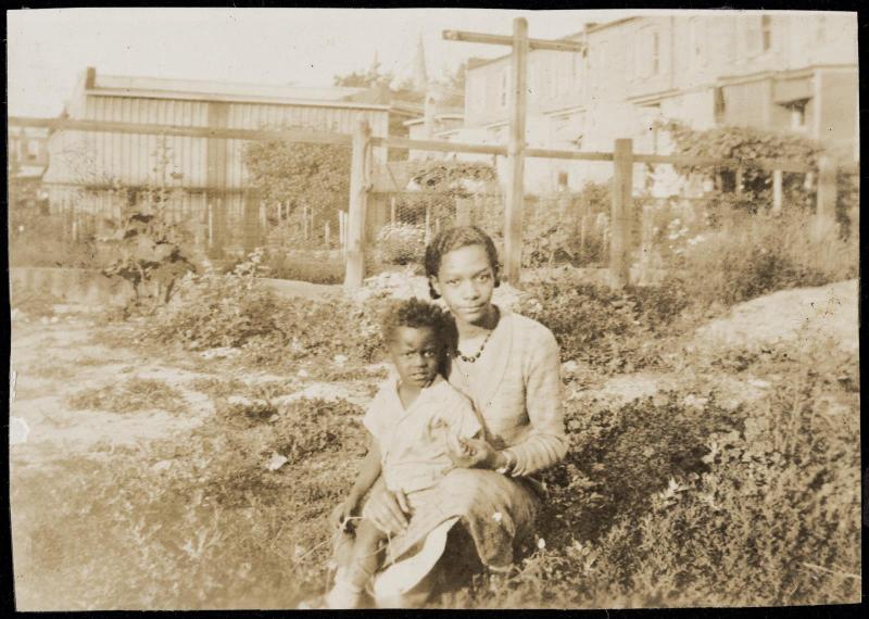 Woman and child seated in an urban garden