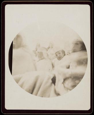 Softly blurred image of several figures in hats and wraps, Moorish wedding