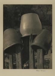 Untitled (clay pots hung on wooden poles)
