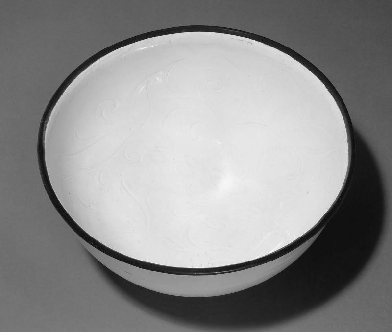 Large bowl with carved lotus design under ivory white glaze and metal rim