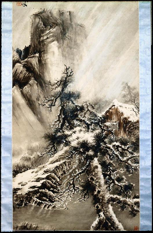 Landscape in a snowstorm with pines and a mill house