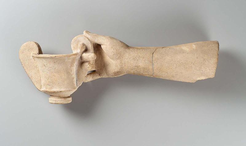Arm and hand, possibly of Dionysos, holding a kantharos