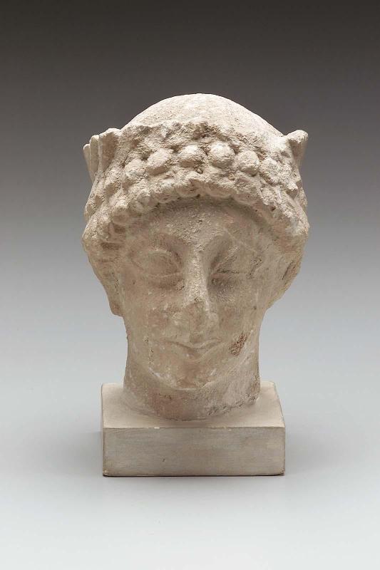 Head of a beardless male votary wearing a wreath of leaves