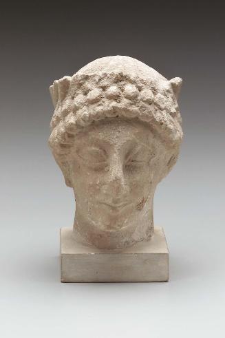 Head of a beardless male votary wearing a wreath of leaves