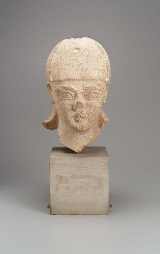 Male votary wearing conical helmet