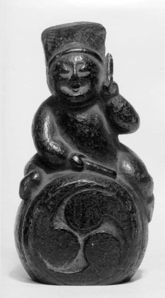 Sculpture of boy sitting on drum
