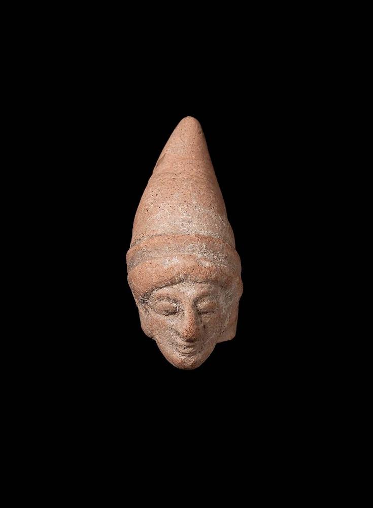 Head of female figurine with tall, pointed pilos