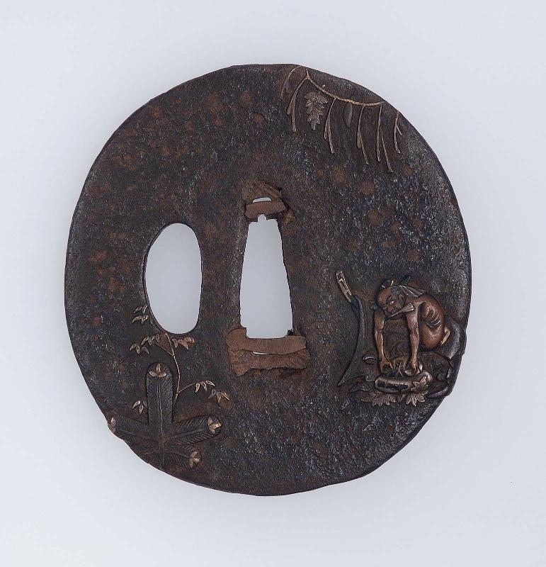 Tsuba with design of seated naked figure with a suehiro fan in his mouth, shimenawa and kadomatsu