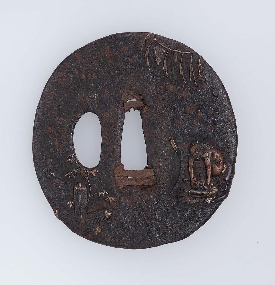 Tsuba with design of seated naked figure with a suehiro fan in his mouth, shimenawa and kadomatsu