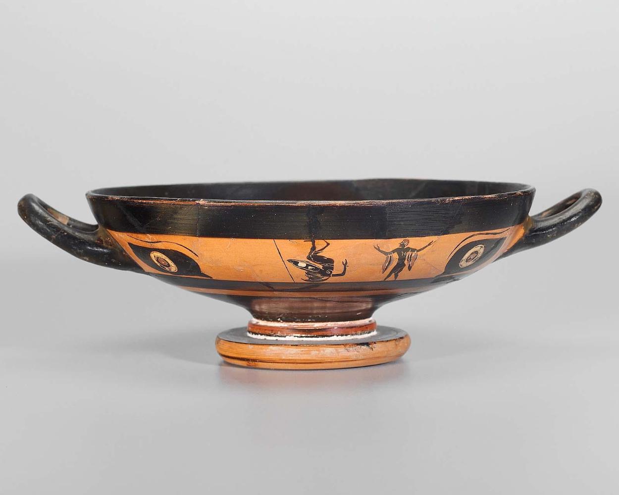 Drinking cup (kylix) depicting a man and a warrior-acrobat