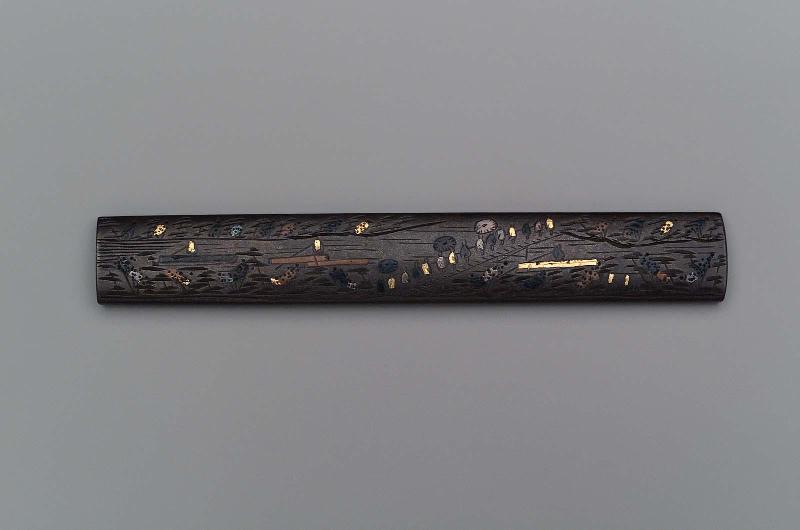 Kozuka with design of autumn landscape with a procession crossing a bridge