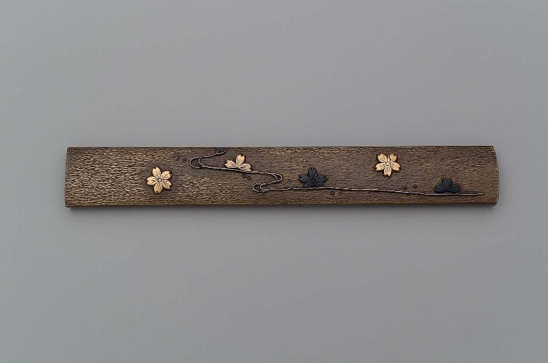 Kozuka with design of cherry blossom floating on a stream