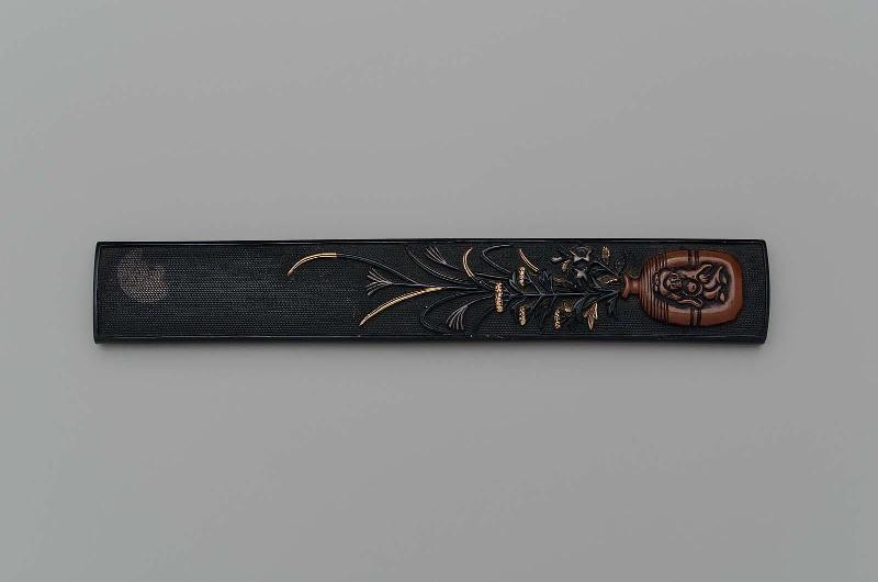 Kozuka with design of susuki and ominaeshi in a Bizen-ware container