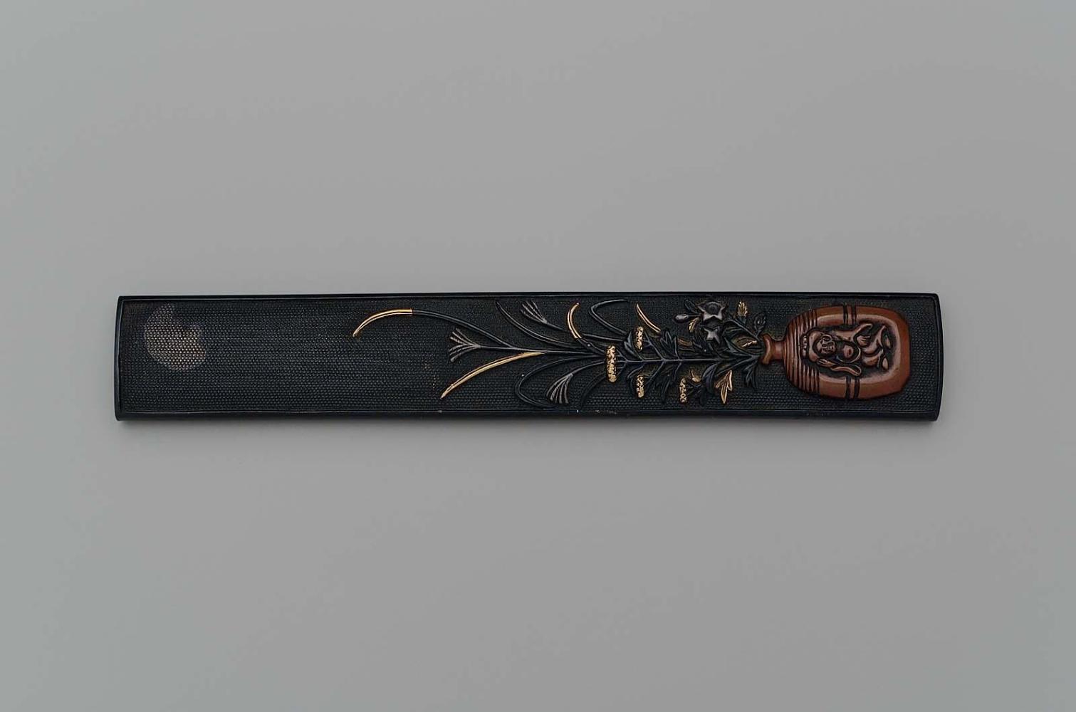 Kozuka with design of susuki and ominaeshi in a Bizen-ware container