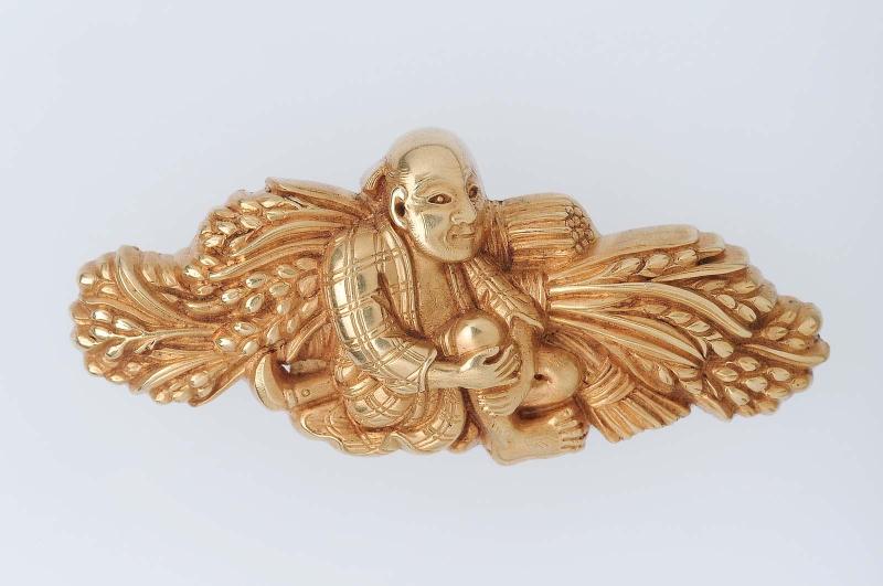 Menuki in the form of a peasant seated with sheaves of rice