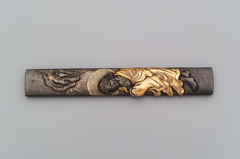 Kozuka with design of Daruma standing beneath a crag