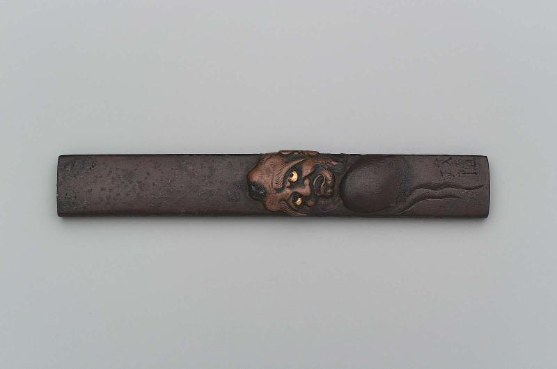 Kozuka with design of Daruma irritated by an insect on his head