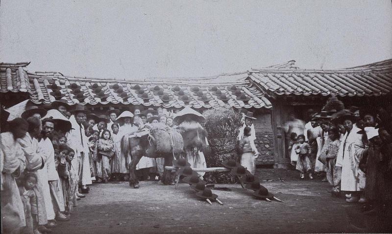 Hat shop in the main street, Seoul: Hats judiciously exposed to view on the roof and in the street (NRICP Relic No.: 2921)