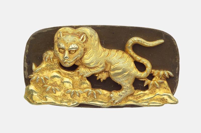 Kanamono in the form of a tiger crouched on a rock, with backplate engraved with bamboo