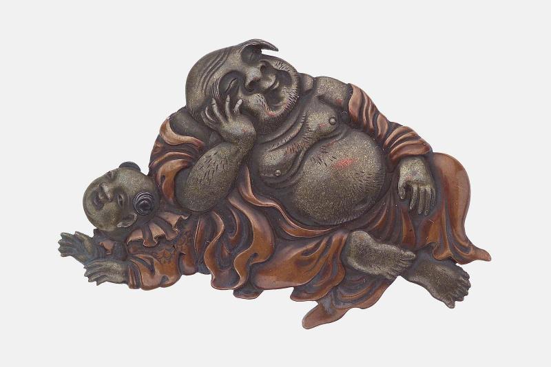 Kanamono in the form of Hotei sleeping with his elbow resting on a karako attendant