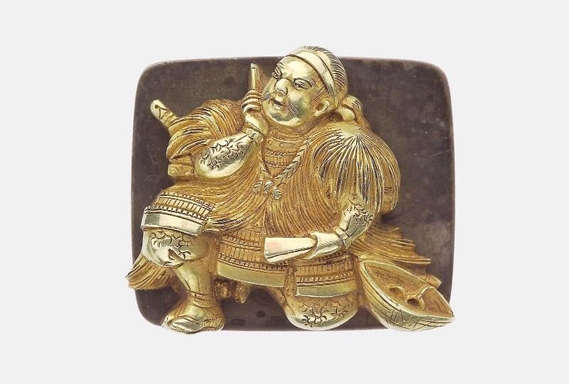 Kanamono in the form of a kneeling samurai dressed in armour and mino, with a straw hat at his side, with backplate